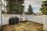 Enjoy outdoor living in this charming backyard oasis! Featuring a cozy seating area, a covered grill, and a pristine white fence, this space is perfect for entertaining or relaxing.