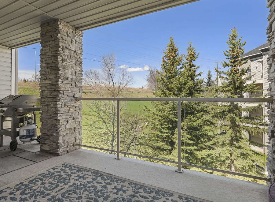 Enjoy breathtaking views from this stunning property! This home features a spacious balcony with a modern glass railing, perfect for relaxing and entertaining.