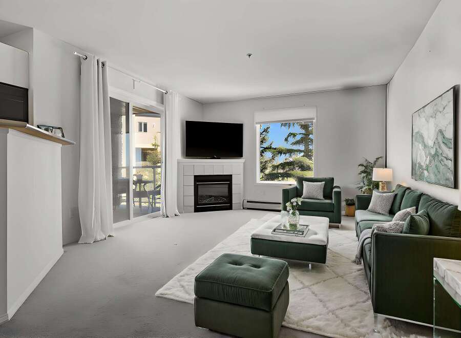 Step into luxury with this stunning property featuring a modern fireplace and elegant green velvet furniture.