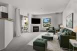 Step into luxury with this stunning property featuring a modern fireplace and elegant green velvet furniture.