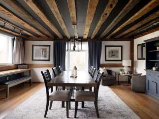 Step into luxury with this stunning dining room, featuring a rustic beamed ceiling and elegant furnishings.