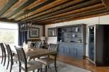 Step into luxury with this stunning dining room, featuring a rustic wooden ceiling and elegant chandelier.