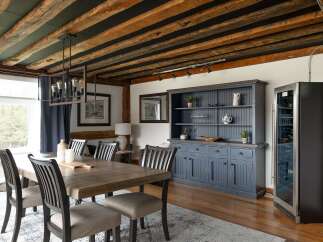 Step into luxury with this stunning dining room, featuring a rustic wooden ceiling and elegant chandelier.