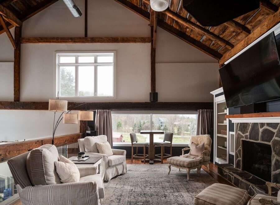 Step into luxury with this stunning property featuring a spacious living area with exposed beams and a cozy fireplace.