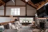 Step into luxury with this stunning property featuring a spacious living area with exposed beams and a cozy fireplace.