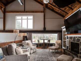 Step into luxury with this stunning property featuring a spacious living area with exposed beams and a cozy fireplace.