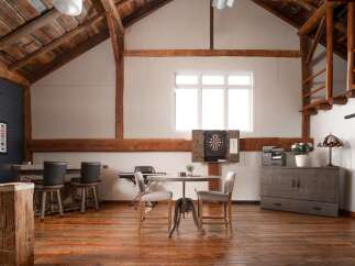 This stunning property boasts a rustic, open-concept design with exposed wooden beams and a warm, inviting atmosphere.