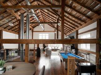 Experience rustic elegance in this stunning property featuring exposed wooden beams and a soaring vaulted ceiling.