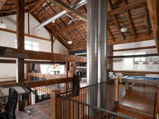 Experience rustic elegance in this stunning property featuring exposed wooden beams and a high, vaulted ceiling.