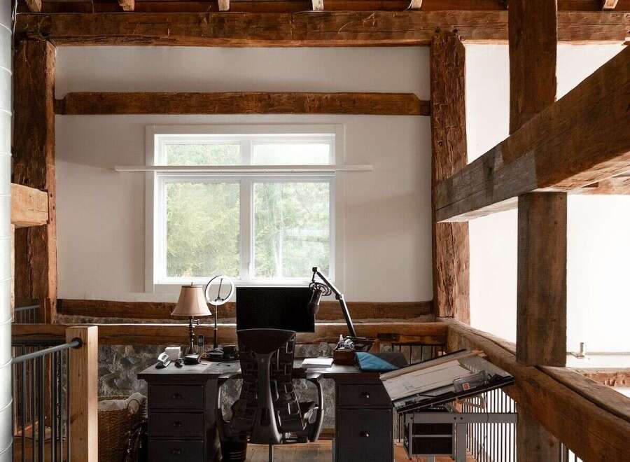 This stunning property boasts a unique, rustic design with exposed wooden beams and a loft-style workspace.