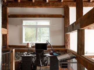 This stunning property boasts a unique, rustic design with exposed wooden beams and a loft-style workspace.