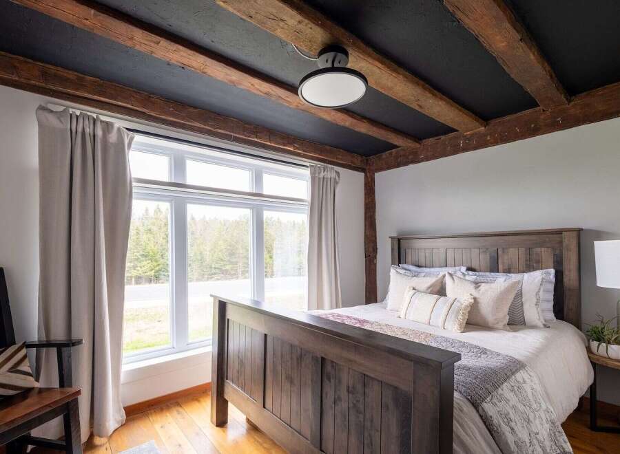This stunning bedroom boasts a rustic charm with its exposed wooden beams and a cozy ambiance.