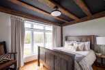 This stunning bedroom boasts a rustic charm with its exposed wooden beams and a cozy ambiance.