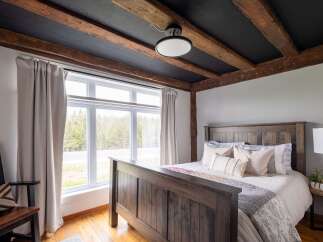 This stunning bedroom boasts a rustic charm with its exposed wooden beams and a cozy ambiance.