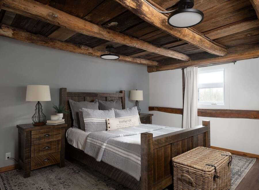 This rustic bedroom showcases a stunning wooden ceiling and a cozy, inviting atmosphere.