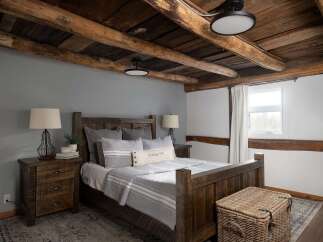 This rustic bedroom showcases a stunning wooden ceiling and a cozy, inviting atmosphere.
