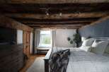 This stunning bedroom boasts rustic charm with its exposed wooden beams and cozy ambiance.