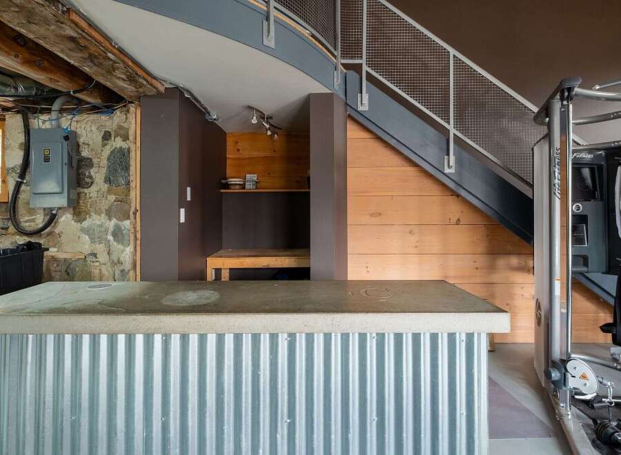 Discover the unique charm of this property, featuring a stylish corrugated metal bar and a functional home gym.