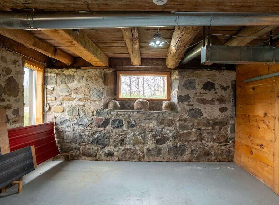 Discover the rustic charm of this unique property, featuring exposed stone walls and wooden beams that exude character.