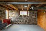 Discover the rustic charm of this unique property, featuring exposed stone walls and wooden beams that exude character.