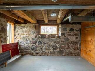 Discover the rustic charm of this unique property, featuring exposed stone walls and wooden beams that exude character.