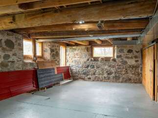 Discover the rustic charm of this unique property, featuring exposed wooden beams and stone walls.