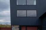 Discover modern living in this stunning property featuring a sleek, dark exterior and contemporary design.