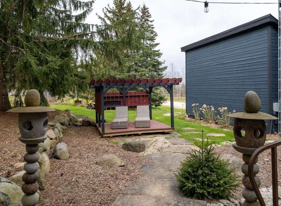 Enjoy the tranquility of this outdoor oasis! This property features a charming pergola with seating, perfect for relaxing or entertaining.