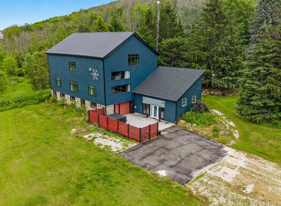 Discover this stunning modern home nestled amidst lush greenery and rolling hills.