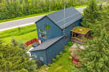 Discover this modern architectural gem featuring a striking dark blue exterior and a unique green roofed gazebo.