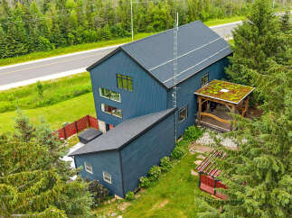 Discover this modern architectural gem featuring a striking dark blue exterior and a unique green roofed gazebo.
