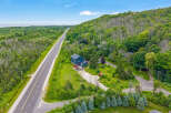 Discover this stunning property featuring a modern dark blue home nestled amidst lush greenery and mature trees.