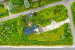 Discover this charming property featuring a modern dark metal roof and a spacious gravel driveway leading to the house.