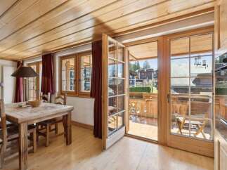 Step into this charming property featuring a warm and inviting dining area with a rustic wooden table and chairs.
