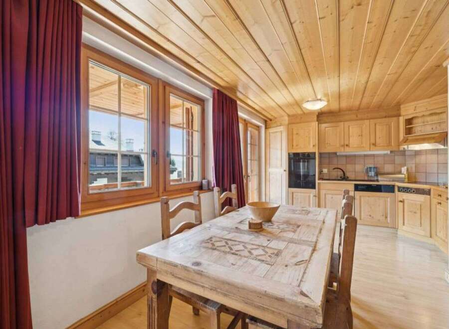 This charming property features a cozy dining area with a rustic wooden table and chairs, perfect for enjoying meals with family and friends.
