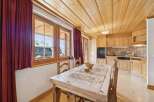 This charming property features a cozy dining area with a rustic wooden table and chairs, perfect for enjoying meals with family and friends.