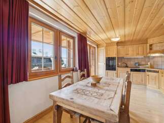 This charming property features a cozy dining area with a rustic wooden table and chairs, perfect for enjoying meals with family and friends.