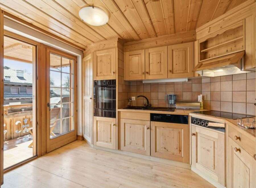 This charming kitchen boasts a warm, inviting atmosphere with its wooden cabinetry and flooring.