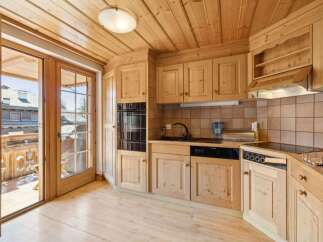 This charming kitchen boasts a warm, inviting atmosphere with its wooden cabinetry and flooring.