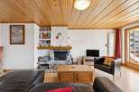 Step into this inviting living space, featuring a cozy fireplace and a warm wooden ceiling.