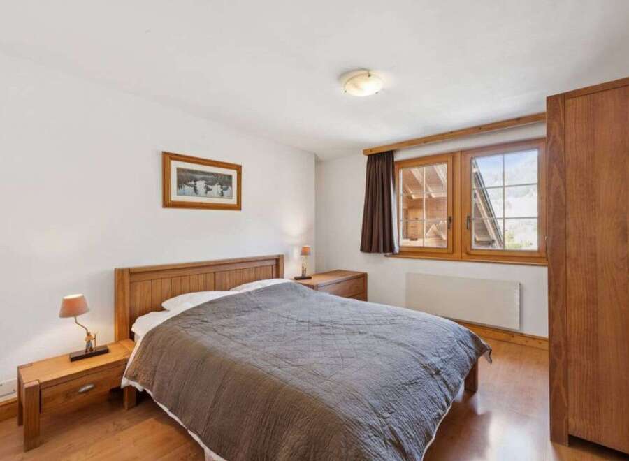 This cozy bedroom features a comfortable bed with a stylish quilt, perfect for a relaxing retreat.