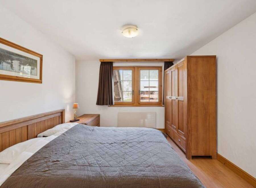 This cozy bedroom features a comfortable bed with a stylish quilt, perfect for a relaxing retreat.