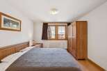 This cozy bedroom features a comfortable bed with a stylish quilt, perfect for a relaxing retreat.