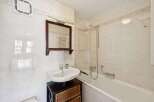 This charming bathroom features a classic design with white tiles and a functional layout.
