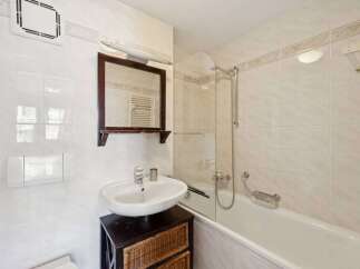 This charming bathroom features a classic design with white tiles and a functional layout.