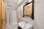 This charming bathroom features a modern shower enclosure, a stylish sink, and a large mirror.