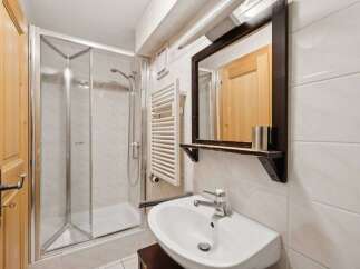 This charming bathroom features a modern shower enclosure, a stylish sink, and a large mirror.