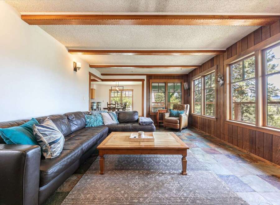 This stunning living room boasts a luxurious leather sectional and a cozy armchair, perfect for relaxing.