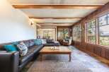 This stunning living room boasts a luxurious leather sectional and a cozy armchair, perfect for relaxing.