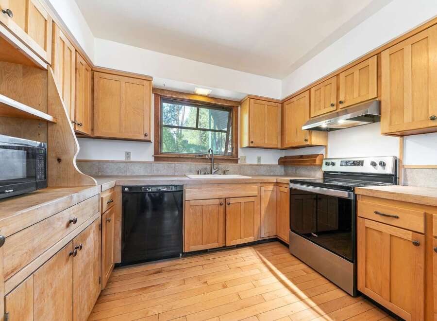 Step into this inviting kitchen, featuring warm wooden cabinetry and a functional layout.